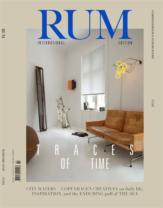 RUM International Edition-forside med en lys stue, brun lædersofa og gul lyskunst under temaet “Traces of Time”.