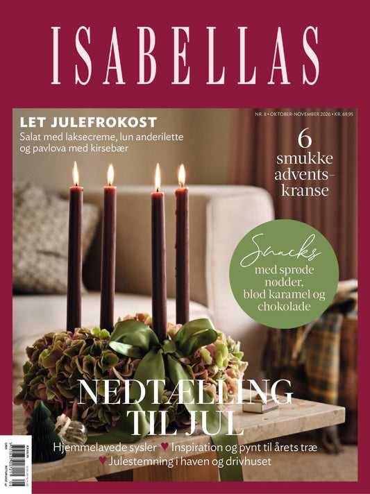 Forside af ISABELLAS nr. 8, oktober–november 2026, med adventskrans med fire tændte lys, hortensiaer og grøn sløjfe. Tema: Nedtælling til jul.